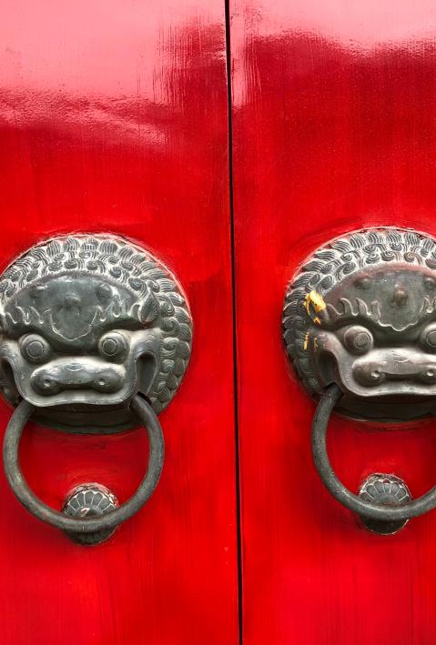 heavy red door with two dragon door knocker