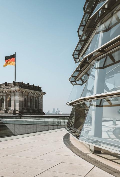 Die Kuppel des Bundestags ist abgeschnitten auf der rechten Seite des Bildes zu erkennen. Links daneben schaut man auf einen der beiden T&uuml;rme mit Deutschlandflagge
