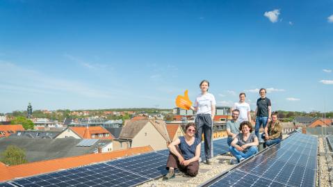 Mitglieder der Energiegenossenschaft Ilmtal posieren neben der auf der Notenbank installierten Solaranlage
